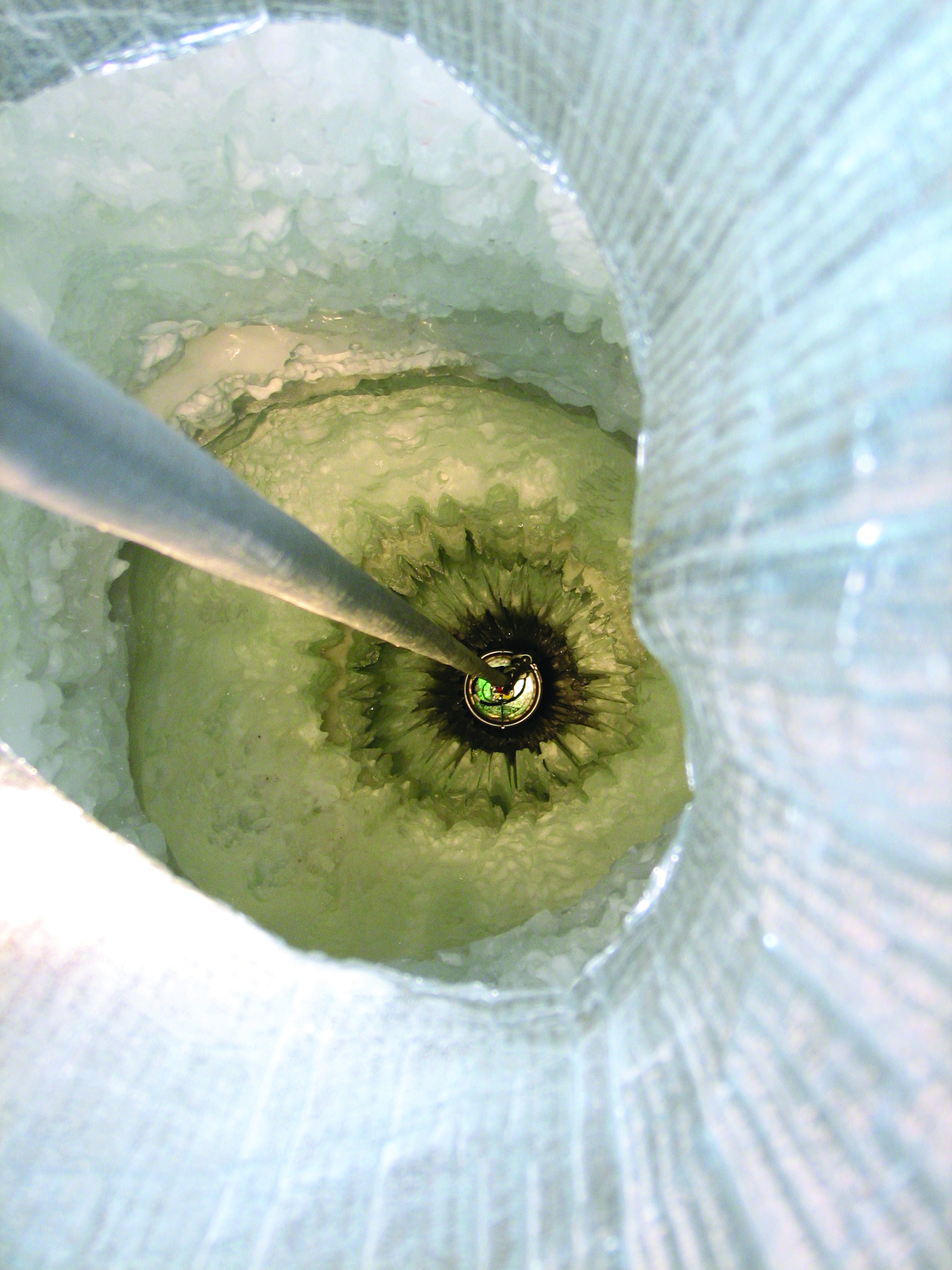 A DOM being lowered into the hole of an IceCube string